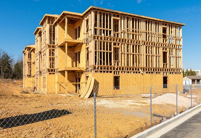 a temporary chain link fence in front of a building under construction, ensuring public safety in Roseland, NJ